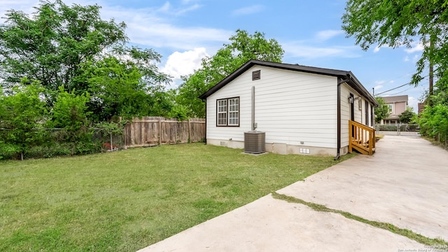 view of outbuilding featuring central AC, fence, and entry steps