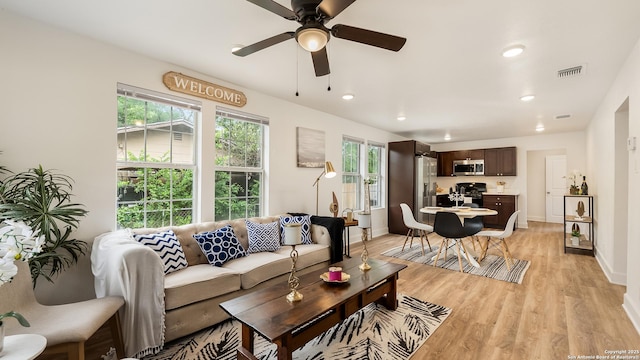 living area featuring light wood-style flooring, visible vents, recessed lighting, and a healthy amount of sunlight