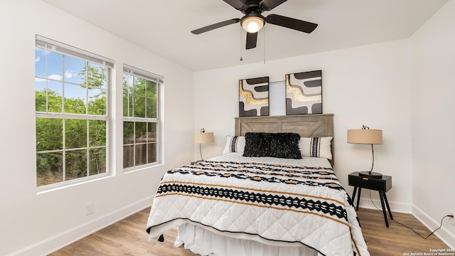 bedroom with wood finished floors, baseboards, and a ceiling fan