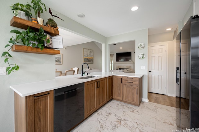 kitchen with open shelves, a fireplace, black dishwasher, light countertops, and a sink