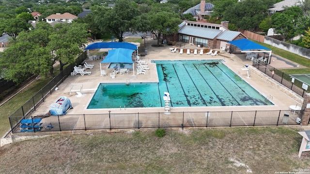 community pool featuring a diving board, a patio area, and fence