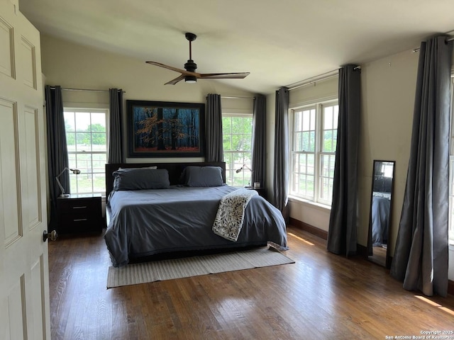 bedroom with vaulted ceiling, ceiling fan, and dark wood-style flooring