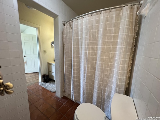 bathroom featuring tile patterned flooring, tile walls, toilet, and a shower with curtain
