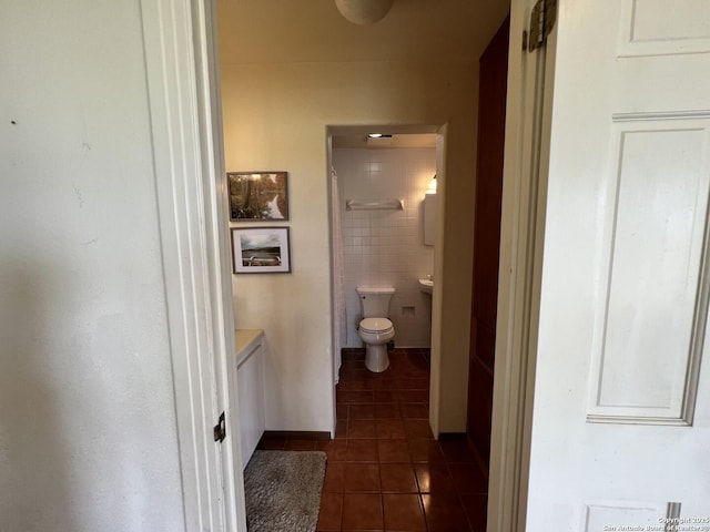 hallway featuring dark tile patterned floors