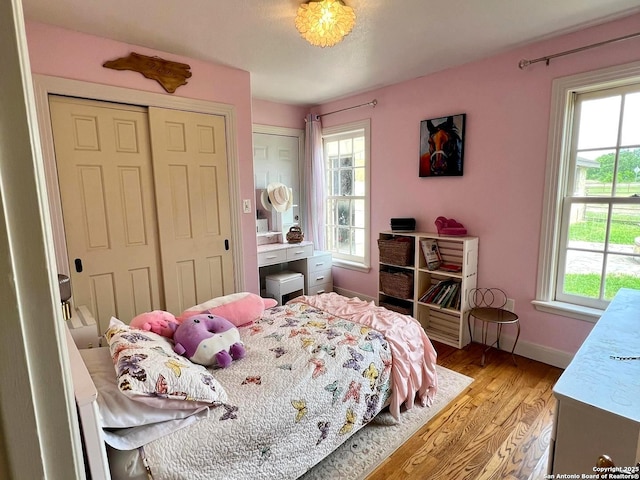 bedroom featuring light wood finished floors and baseboards