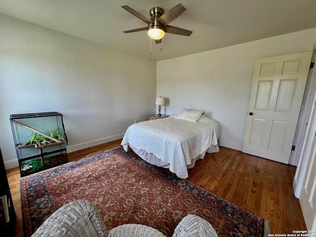 bedroom featuring wood finished floors, a ceiling fan, and baseboards