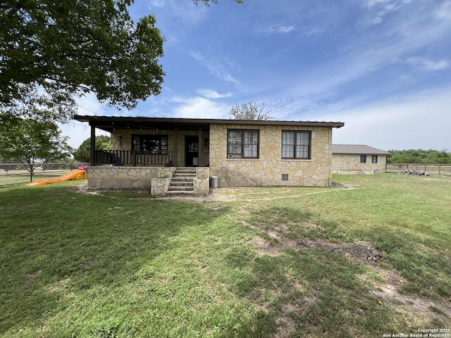 view of front of house with a front lawn, fence, stone siding, and crawl space