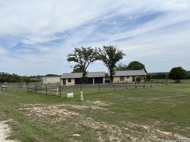 view of yard featuring a rural view, fence, and an outdoor structure