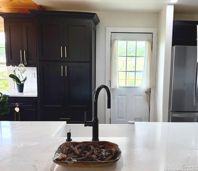 interior space with light countertops, freestanding refrigerator, and a sink