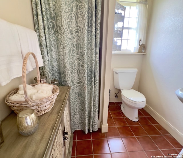 full bathroom with tile patterned flooring, baseboards, and toilet