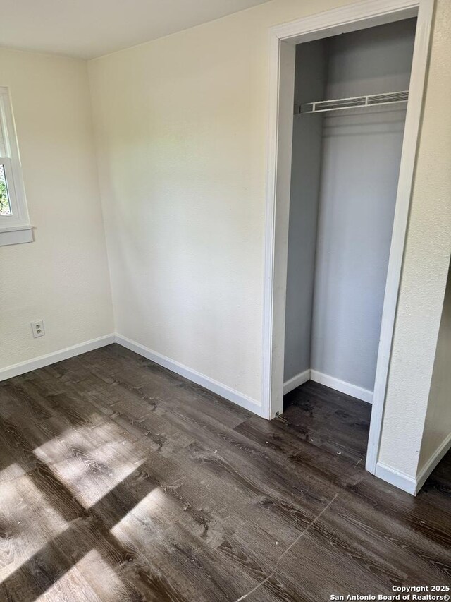 705 Short, Seguin, TX 78155 - unfurnished bedroom featuring baseboards, dark wood-style floors, and a closet
