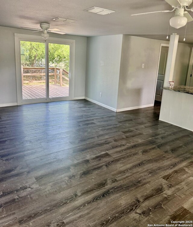 705 Short, Seguin, TX 78155 - spare room featuring visible vents, baseboards, ceiling fan, and dark wood-style floors