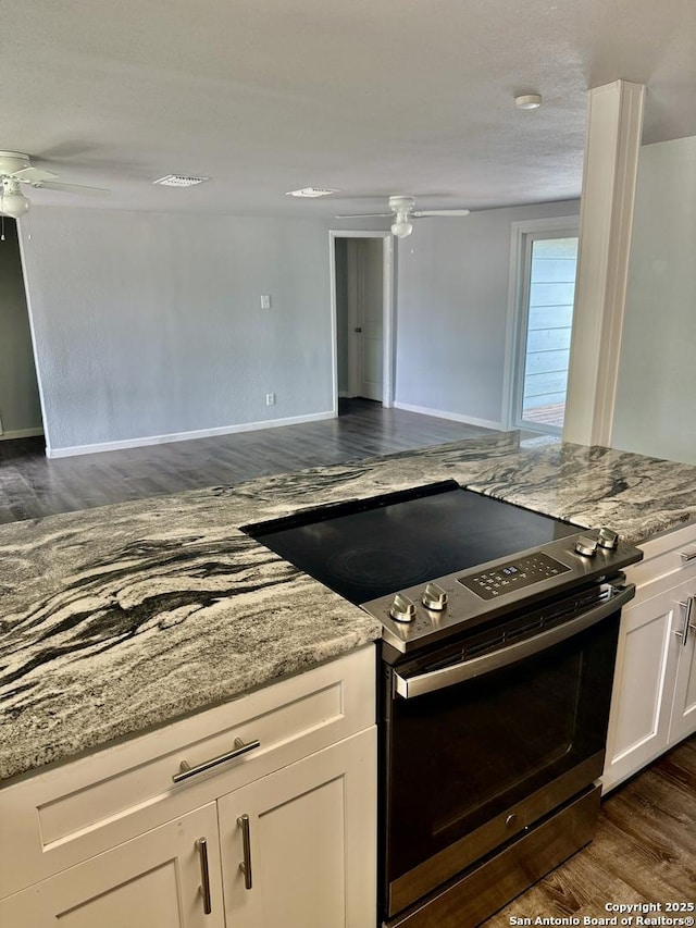 705 Short, Seguin, TX 78155 - kitchen featuring electric stove, a ceiling fan, light stone countertops, dark wood-style flooring, and white cabinetry