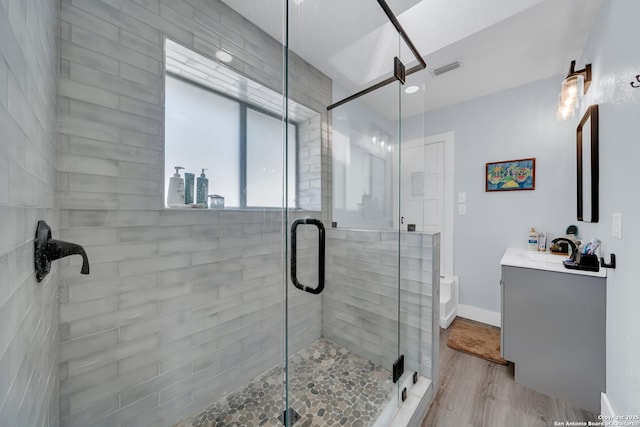 bathroom with visible vents, wood finished floors, vanity, and a shower stall