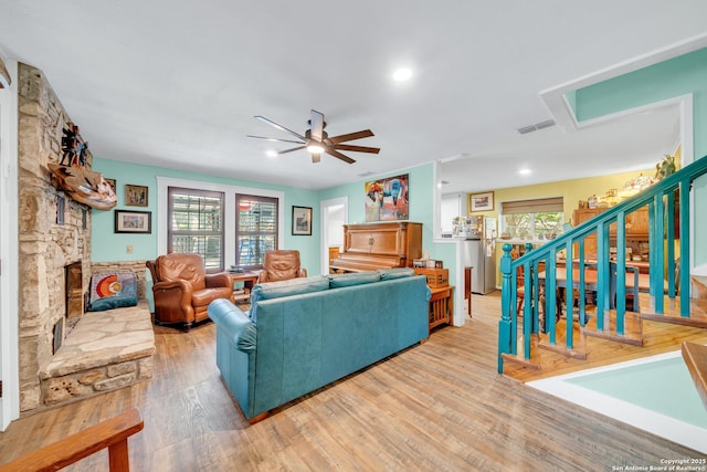 living room featuring a ceiling fan, visible vents, a healthy amount of sunlight, and light wood-style flooring
