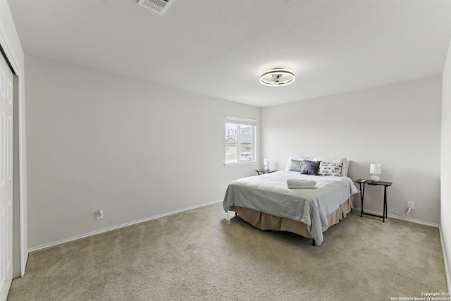 carpeted bedroom featuring baseboards, visible vents, and a closet
