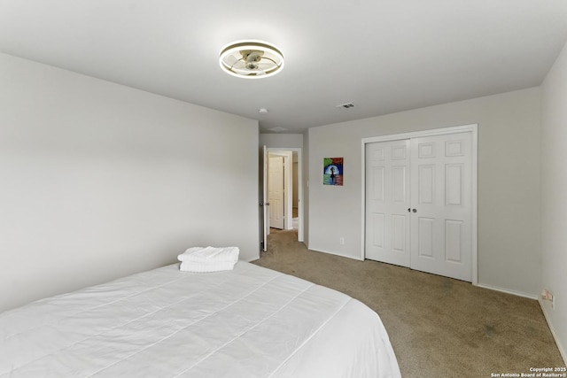 carpeted bedroom with baseboards, visible vents, and a closet
