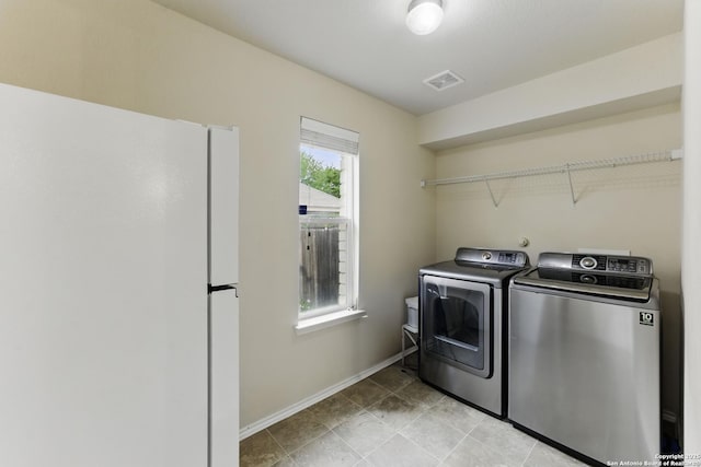 clothes washing area featuring separate washer and dryer, light tile patterned flooring, laundry area, baseboards, and visible vents