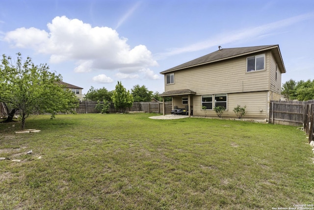 back of property with a patio area, a lawn, and a fenced backyard