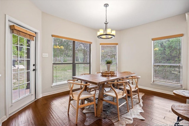dining space featuring baseboards, a chandelier, and dark wood-style floors