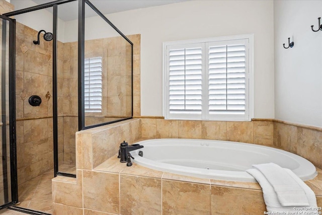 full bathroom with a shower stall, a wealth of natural light, and a bath