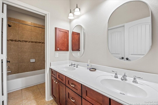 bathroom with shower / bathing tub combination, double vanity, tile patterned floors, and a sink