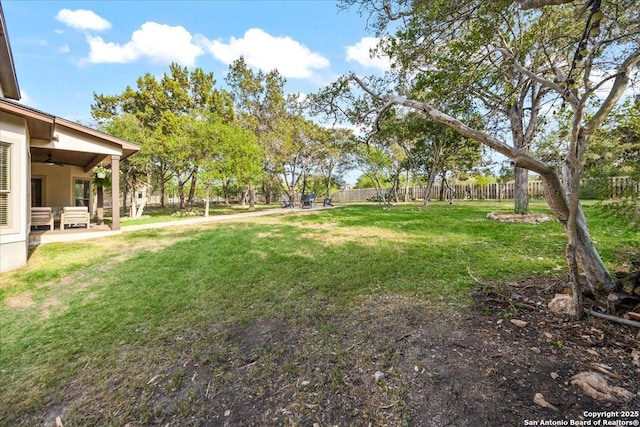 view of yard with fence, a patio area, and a ceiling fan
