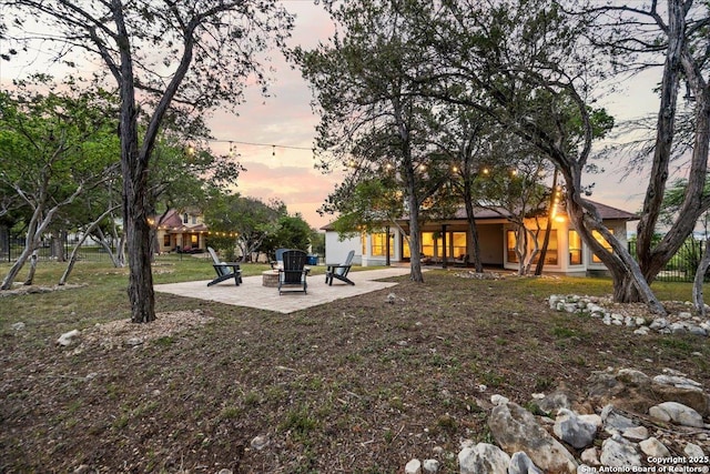 yard at dusk with a fire pit and a patio