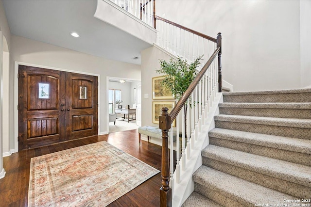 foyer with recessed lighting, stairway, baseboards, and wood finished floors
