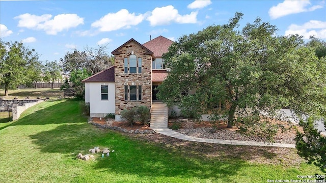 back of house featuring a shingled roof and a yard