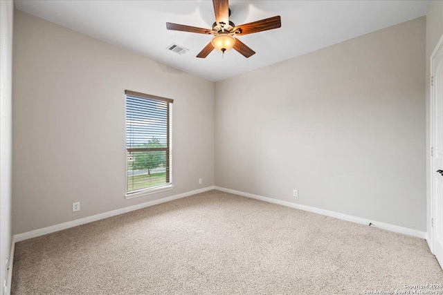 unfurnished room with carpet floors, visible vents, and baseboards