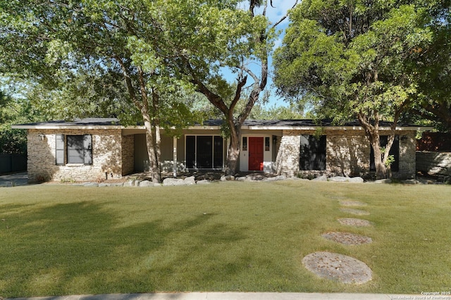 ranch-style home with stone siding and a front yard