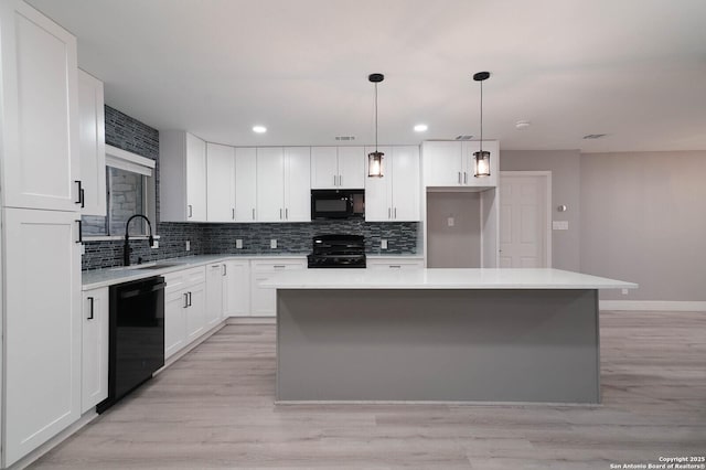 kitchen with black appliances, decorative backsplash, white cabinets, and light countertops