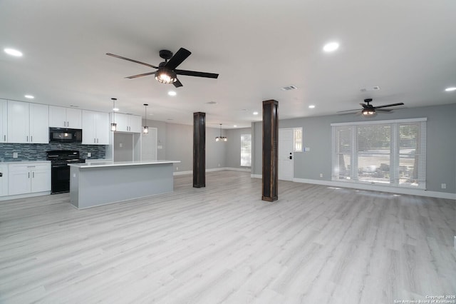 kitchen featuring open floor plan, ornate columns, black appliances, and ceiling fan