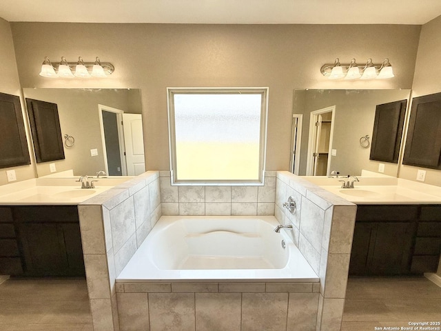 full bathroom with a garden tub, a sink, and two vanities