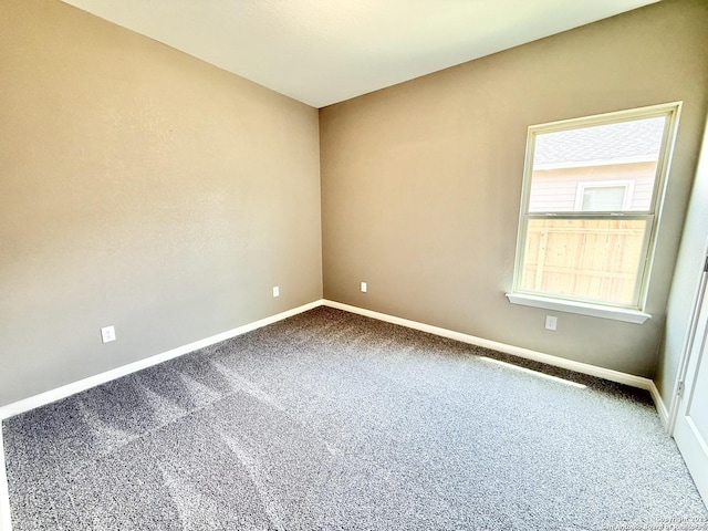 carpeted spare room with baseboards