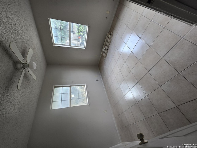 spare room with a ceiling fan and a healthy amount of sunlight