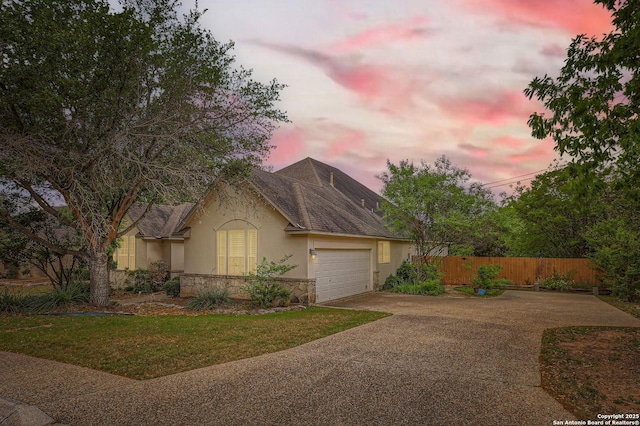 single story home with driveway, fence, an attached garage, a front yard, and stucco siding