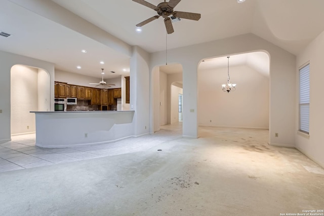 unfurnished living room featuring arched walkways, vaulted ceiling, recessed lighting, light colored carpet, and ceiling fan with notable chandelier