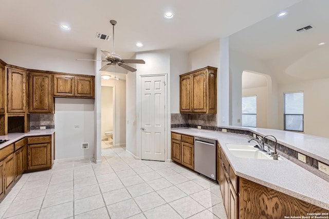 kitchen featuring a ceiling fan, a sink, dishwasher, arched walkways, and visible vents
