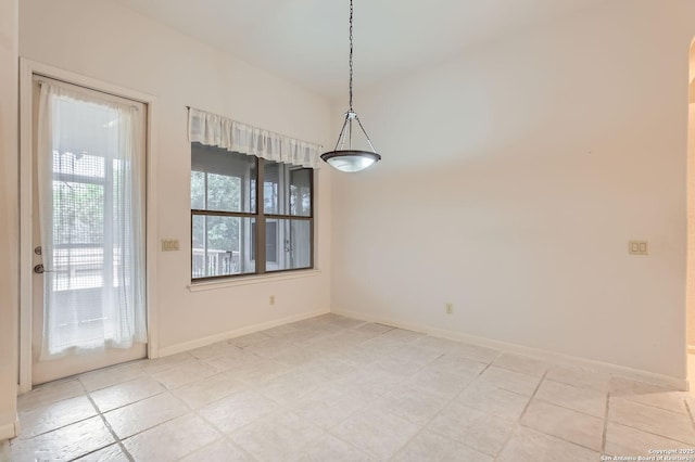 unfurnished dining area with baseboards and light tile patterned floors