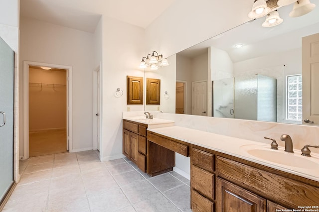 bathroom with a sink, a stall shower, a walk in closet, double vanity, and tile patterned flooring