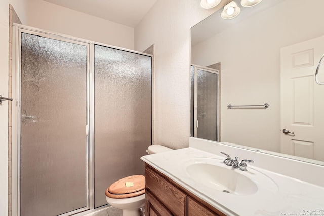 full bathroom with a stall shower, vanity, and toilet