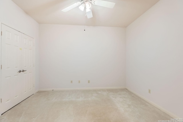 empty room featuring a ceiling fan, baseboards, and light colored carpet