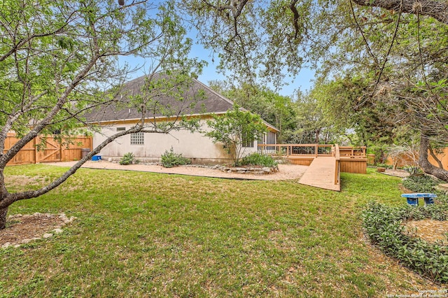 view of yard featuring fence and a deck