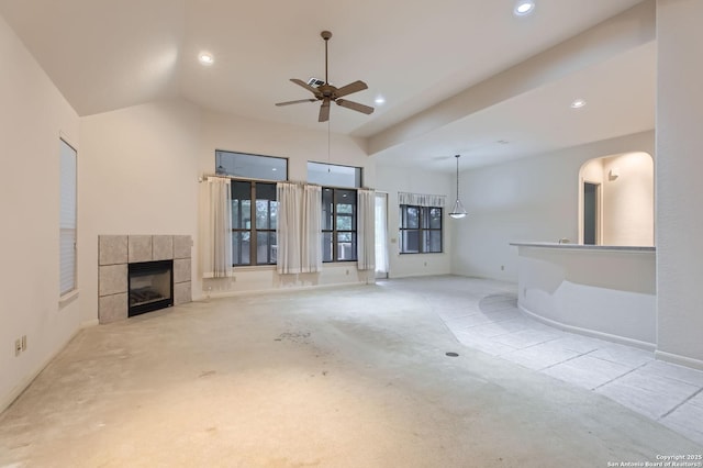 unfurnished living room featuring arched walkways, recessed lighting, a ceiling fan, a tile fireplace, and carpet floors