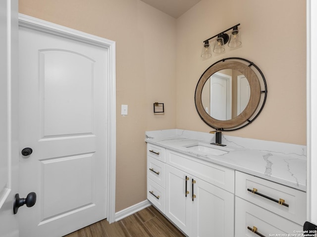 bathroom with wood finished floors, vanity, and baseboards