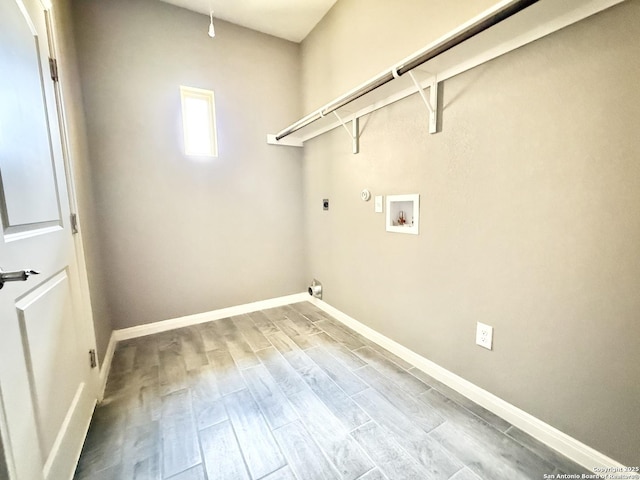 clothes washing area featuring laundry area, wood finished floors, hookup for a washing machine, baseboards, and electric dryer hookup