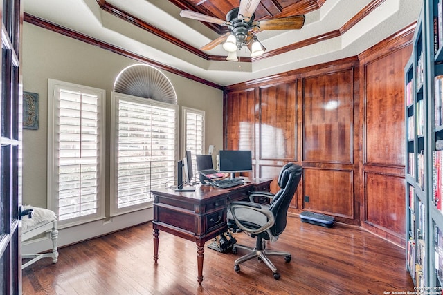 office area featuring ceiling fan, wood finished floors, ornamental molding, and a raised ceiling