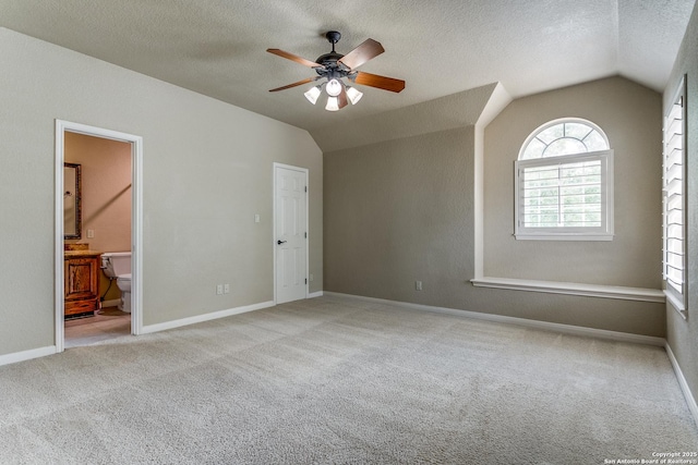 spare room featuring ceiling fan, vaulted ceiling, and light carpet